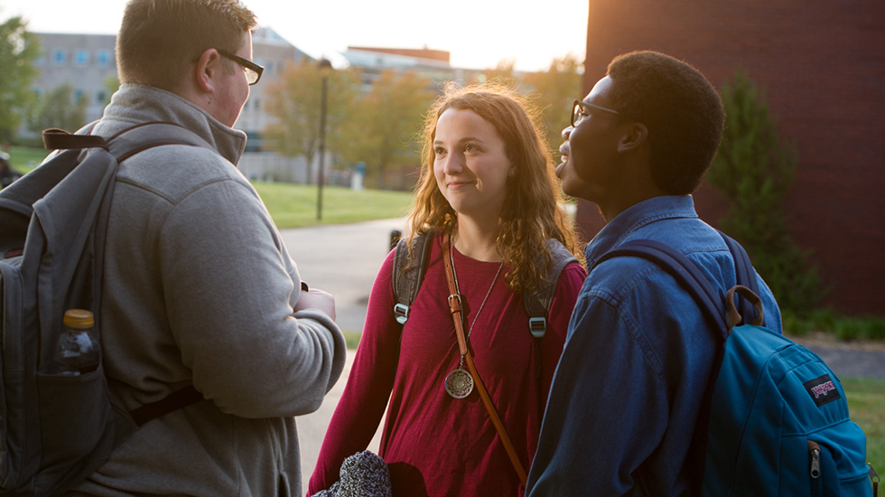students talking outside at sunset