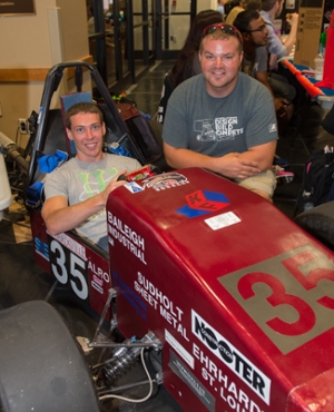 Members of the Formula SIUE organization pose with a racecar they built.
