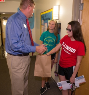 Vice Chancellor for Student Affairs Jeffrey Waple greets and offers candy to Jill Crabtree, a freshman majoring in marketing, and Maddie Barra, freshman psychology major, both from Pekin, Illinois.