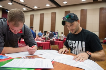 Brian Meyer (L) and Shaun Morgan (R), both undergraduate students at SIUE, fill out their graduate school admissions forms.