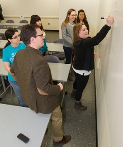 Jeffrey Manuel, associate professor of historical studies at SIUE, and a group of students utilize the expansive whiteboard in the Adaptive Learning Environment classroom.