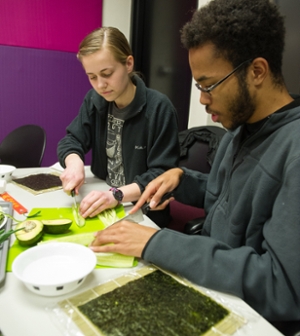 SIUE students Tess Brown (L) and Justin McCloud (R) slice ingredients for their sushi rolls.