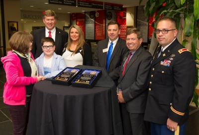 The Tipton family, Kaitlyn, Austin and Susie, pose with (L-R) SIUE's Jeffrey Waple, John Navin, Stephen Hansen, and Lt. Col. Scott Reed.