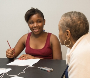 Serenity McKenney interviews a woman at the Clyde C. Jordan Senior Center in East St. Louis.