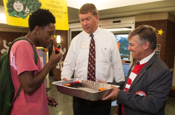 Javon Williams, of St. Louis, receives a sweet treat from Vice Chancellor for Student Affairs Jeffrey Waple (middle) and Chancellor Dr. Randy Pembrook during the annual House Calls event.