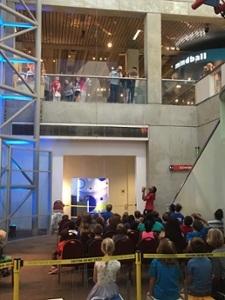 Noyce intern and SIUE sophomore Christian Watts leads a science show for a large group of visitors at the St. Louis Science Center.