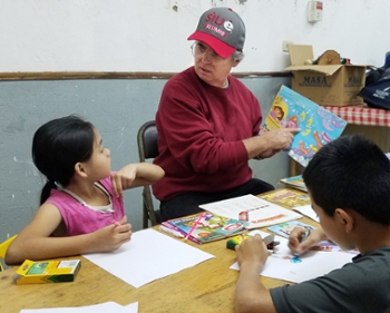 SIUE Chancellor Dr. Randy Pembrook reads to a small group of children during his service trip to Costa Rica.