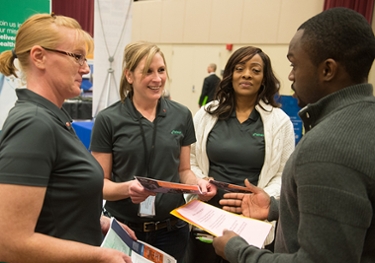Representatives from Patheon, including two SIUE alumni, speak with a current student during the spring career fair.