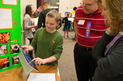 A student presents his STEM-focused project to a pair of judges during the Science Engineering Research Challenge held at SIUE.