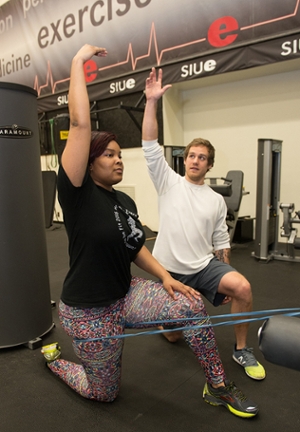 SIUE senior Cody Snyder, a native of Shelbyville, leads a participant in stretches during one of this project team’s training sessions.