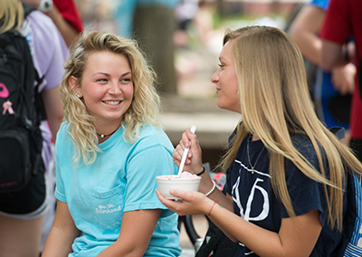Students Brittney Koter and Alexa Humphreys enjoy ice cream on the Quad during Springfest.