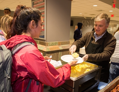 SIUE Chancellor Randy Pembrook serves scrambled eggs to junior nursing student Jasmine Gaona.