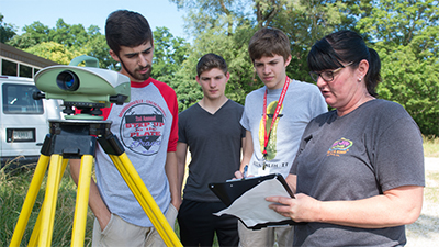 A representative from IDOT instructs campers on land surveying.