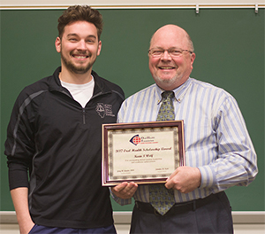 SIU SDM Dean Dr. Bruce Rotter (R) presents the Oral Health Foundation Pierre Fauchard Academy Scholarship for 2017 to third-year student Kevin Wolf (L).