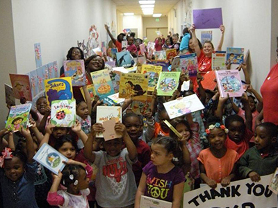 Children in the SIUE Head Start/Early Head Start Program happily display books that have been donated to them.