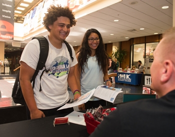 Kaleb Dothard, a freshman accounting student from Moline, and Jazmin Torres, a freshman elementary education major from Moline, speak with a representative from the Special Olympics during the Volunteer Fair.