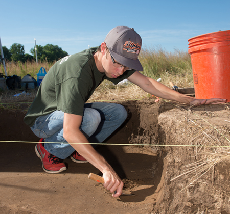 Ethan Troyer, a junior at Boston University, carefully scraps dirt at SIUE’s archeological site.