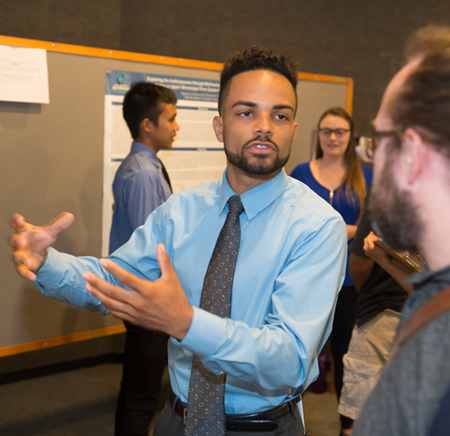 Colby Williams, a junior at the University of South Florida, explains his research project during the REU Symposium at SIUE.