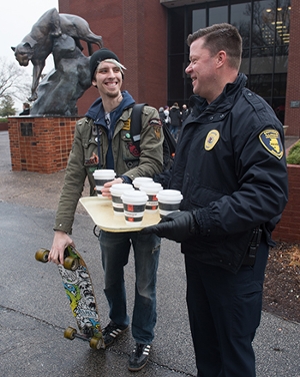 Senior computer science major Matthew Michaels accepts a hot chocolate during the first day of classes from SIUE Police Chief Kevin Schmoll.