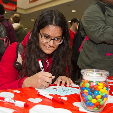 Sophomore chemistry major Maya Sante guesses the number of m&m's in the jar during the I Heart SIUE event.