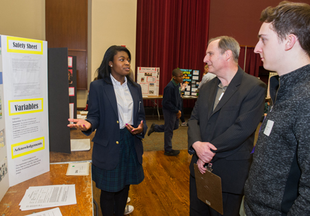 Breanna Goyea, a sophomore at Governor French Academy in Belleville, presents her research to two judges during the Science and Engineering Research Challenge at SIUE.