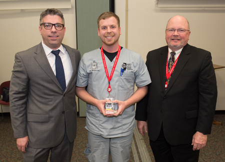 Joshua Gremillion with Dentsply (L) presented the Table Clinic Competition's first place award to SIU SDM second year student Coleman Choate (middle), with Dean Bruce Rotter, DMD, (R) standing alongside.