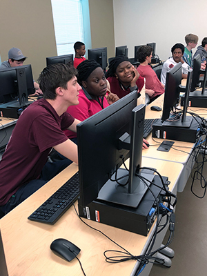 SIUE computer science student Eli Ball assists high school participants at the WeCode event.