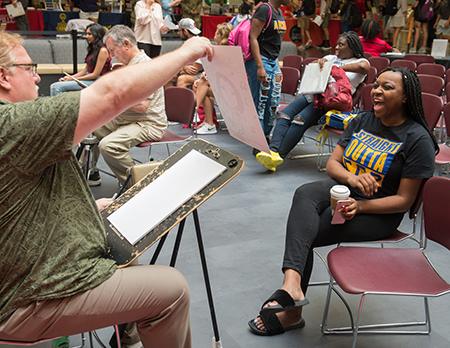 Capri Wroten, of Chicago, reacts happily to her newly created caricature during the SIUE Resource Fair.