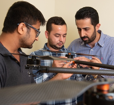 SIUE School of Engineering’s Nima Lotfi, PhD, (back) and his students Nedret Ramic (middle), a mechanical engineering graduate student, and Pratik Lamsal, a senior mechanical engineering major, assemble a large drone.