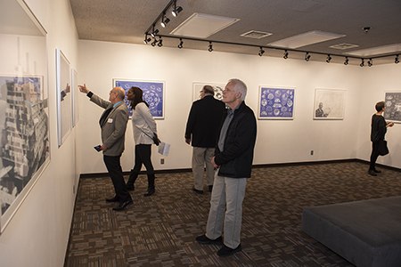 Attendees at the Fuller Dome Gallery opening enjoy the exhibition of R. Buckminster Fuller’s art print portfolio entitled Inventions: Twelve Around One. 