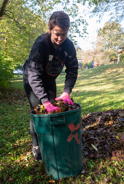 P1 student Lesley Swick loads a can full of leaves in an Edwardsville yard.
