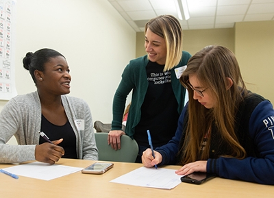 SIUE computer science alumna Darla Ahlert works with participants at SheCode 2018, including Breanna Goyea (left) from Governor French High School in Belleville, and Skylar Phenix (right), from Highland High School.