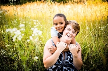 Smiling brightly with her son is SIUE’s Anni Reinking, EdD, assistant professor in the School of Education, Health and Human Behavior’s Department of Teaching and Learning, and author of “Not Just Black and White.”