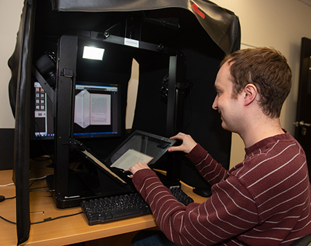 IRIS Center Technician Ben Ostermeier uses the IRIS Center’s equipment to digitize a book. 