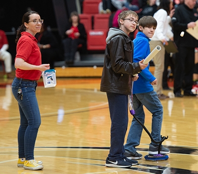 SIUE STEM Center’s Carol Colaninno looks on as David Adams and Garrett Floyd from Trimpe Middle School see how far they can launch a marshmallow.