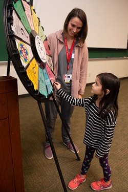 A kindergarten student spins an information wheel during an educational visit to the SIU School of Dental Medicine.