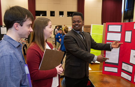 Edwardsville High School senior Amari Brooks presents his research to two volunteer judges during the regional Science and Engineering Research Challenge at SIUE.