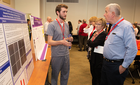 Second-year student Alex Funk describes his research involving electronic cigarettes during the Student Table Clinic Displays.