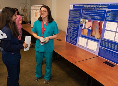 Second-year student Janice Choo presents her research project to a fellow student.