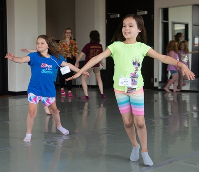 Cougar Theater Camp participants Brooke Vickery (back) and Liz Heil (front) glide across the dance floor while practicing a number for Frozen, Jr.