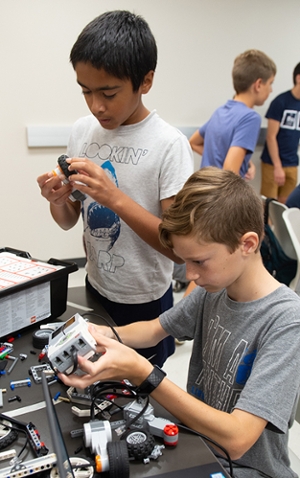 (L-R) Vimal Buckley, of Clayton, MO, and Xavier Wilson, of Glen Carbon, work intently to build their robot.