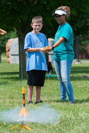 Will Cameron, of Glen Carbon, launches a rocket he made during Odyssey Science Camp. Working alongside him is Candi Johnson with the SIUE STEM Center.