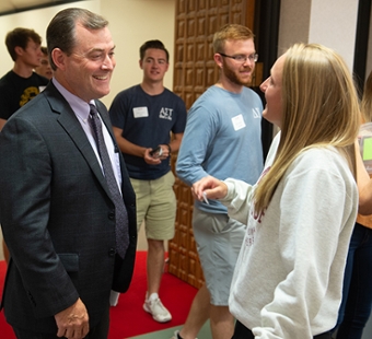 SOP Dean Mark Luer greets a first-year student during the 2019 New Student Orientation Luncheon.