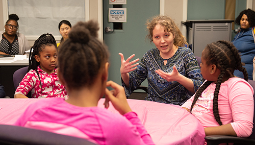 April Pritchard, PhD, shows girls an aircraft model while inspiring them to consider a STEM field.