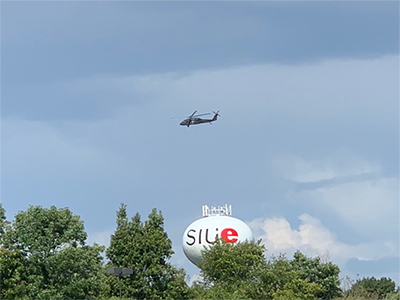 A UH-60 Black Hawk flies over the SIUE campus.