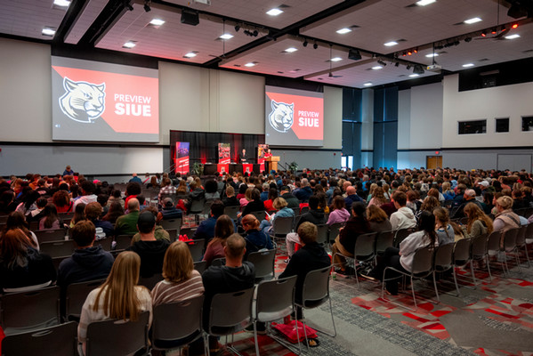 Room full of seated crowd looking at SIUE Preview Day monitors