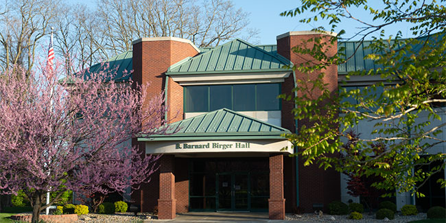 A full frontal view of Birger Hall with some trees in the front of it