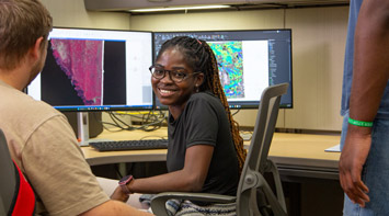 SIUE student smiling at computer.