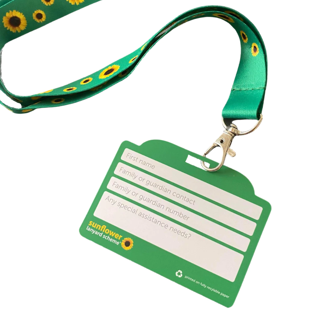 A green Hidden Disabilities Sunflower Lanyard with small sunflowers all over it, holding an ID card