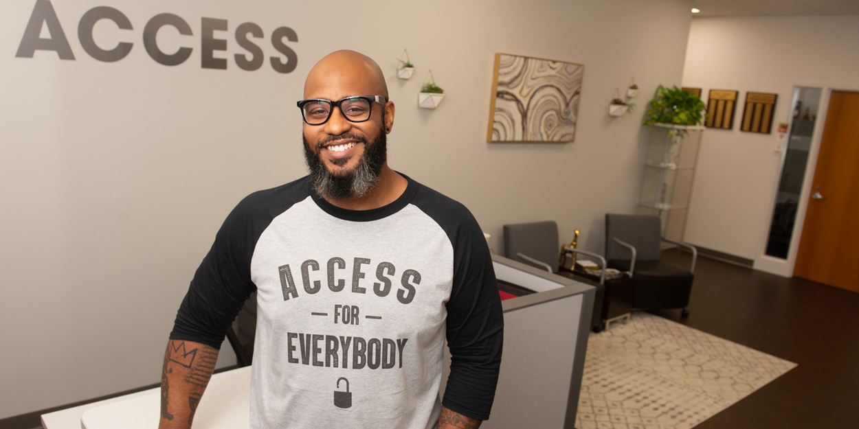 ACCESS Director Dominic Dorsey smiling in front of ACCESS sign